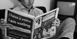 Student reading an issue of the Fulcrum newspaper