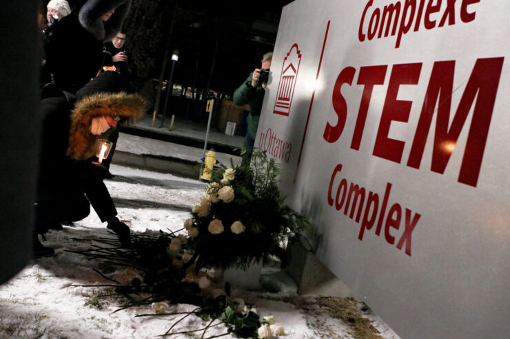 People laid down white flowers outside of the STEM Complex building to pay respect to the victims following the vigil. Photo: Aaron Hemens/Fulcrum