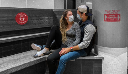 Two people with masks sitting together romantically