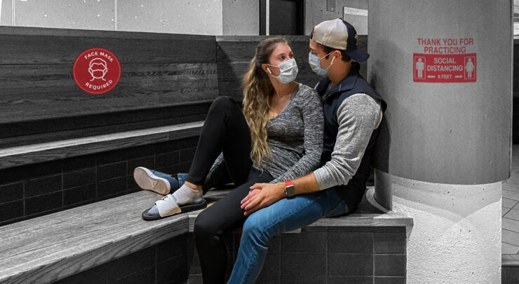 Two people with masks sitting together romantically