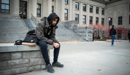 Image of a student looking sad on campus