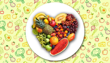 A plate of vegetables and fruits forming a heart