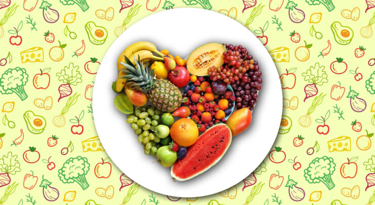 A plate of vegetables and fruits forming a heart