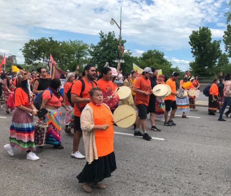 women banging a traditional drum during the protest