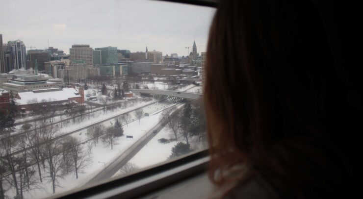 student looking out the window of her residence