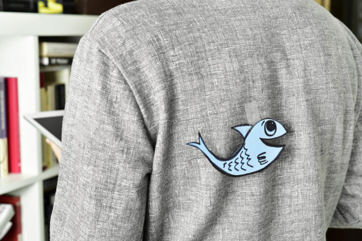 paper fish on someone's back