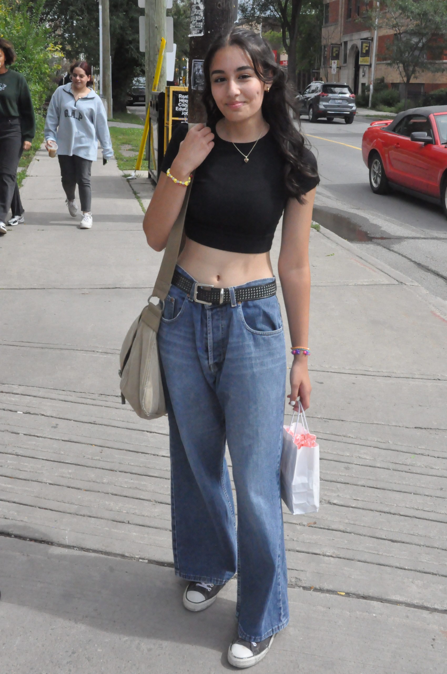 U of O student wearing low-rise jeans paired with a baby tee and shoulder bag