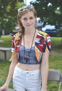 Student posing on campus wearing a patterned cropped blazer and tank top. 