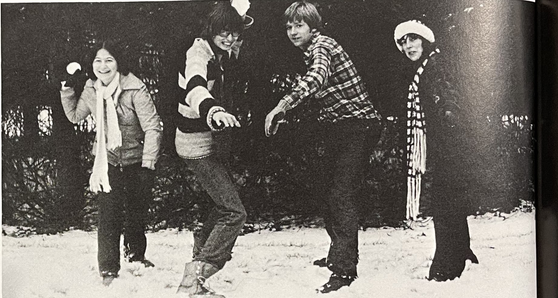 Four U of O students posing in a stance about to throw snowballs towards the camera. 