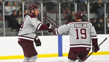 Two Gee-Gees hockey players bump fists on the rink.