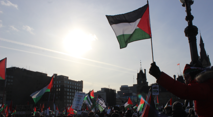 A Palestinian flag waving in the sky during a rally for Palestine.