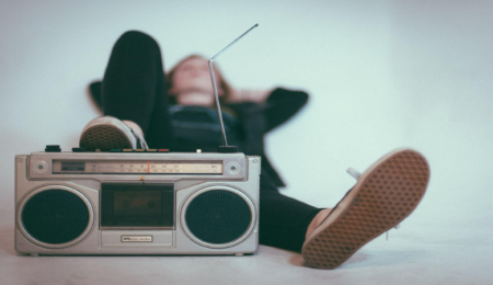 person laying back and listening to music with their foot resting on a radio