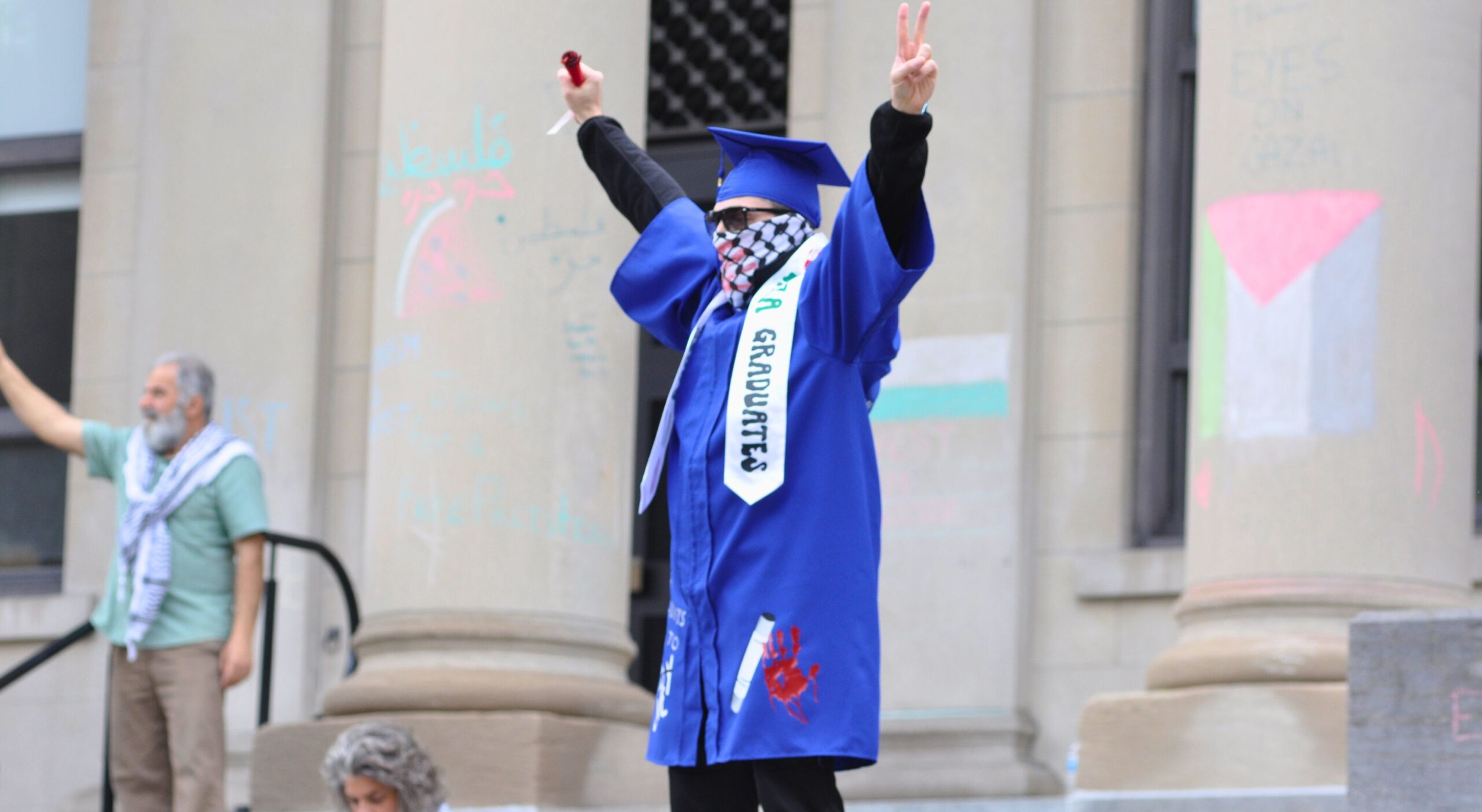 protester dressed in blue graduation gown
