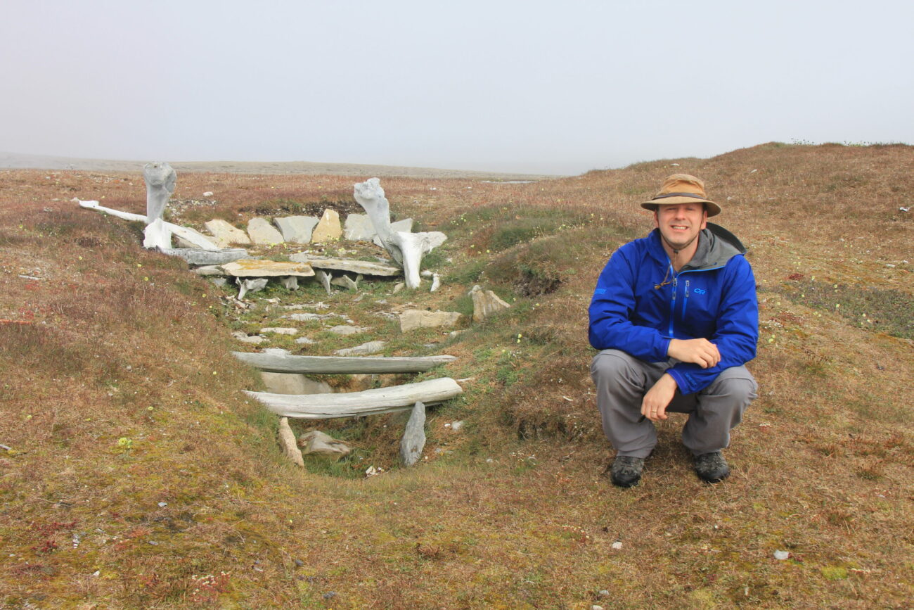 Jules Blais poses beside whale bones in a Thule settlement.