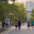 A photo of people walking across a university campus with a tomato logo in the corner