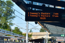 A sign with light rail wait times: “tunney’s pasture comes in 7 mins; tunney’s pasture comes in 17 mins”