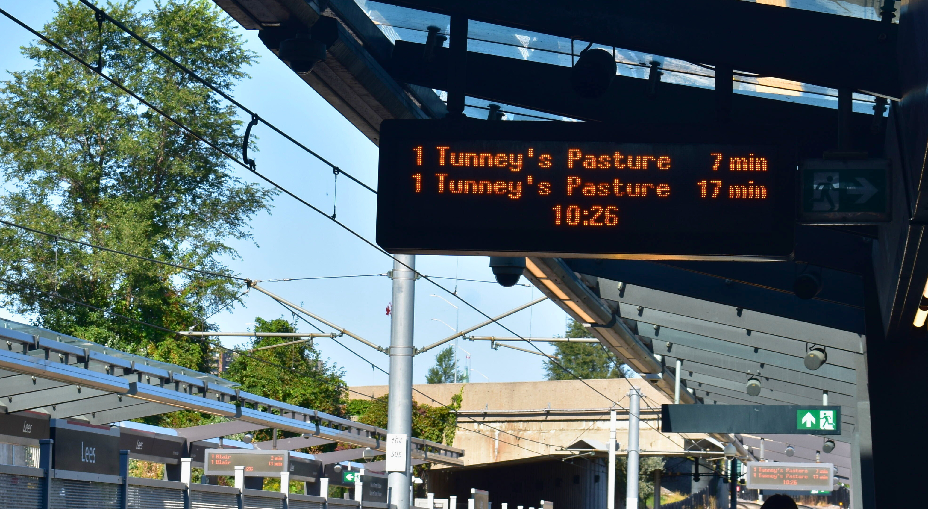 A sign with light rail wait times: “tunney’s pasture comes in 7 mins; tunney’s pasture comes in 17 mins”