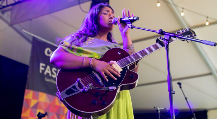 Amanda Lowe performs on Fasken Stage with purple light shining on them.