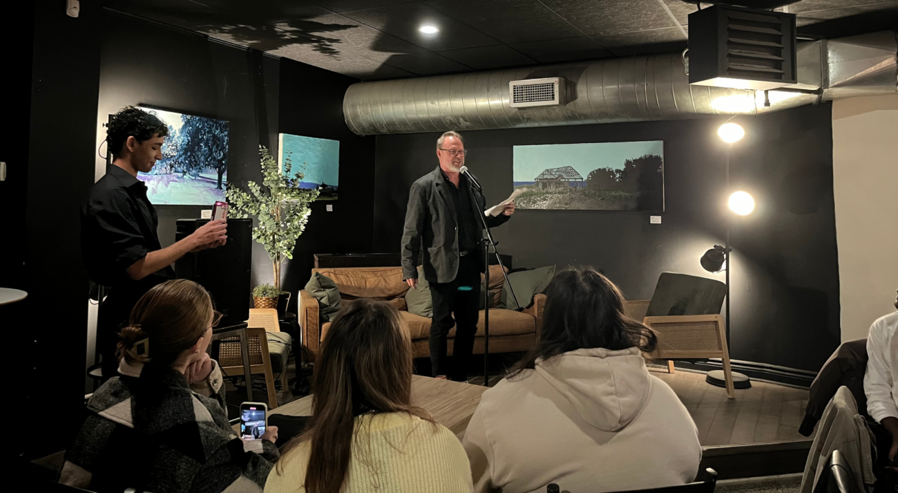 Robert Stacey, Chair of the Department of English, recites a poem to an audience at Blue Monday.