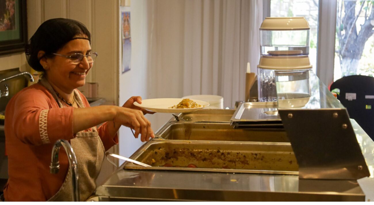 Govinda's volunteer smiles while serving food