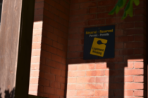 A U of O housing sign on a brick wall.